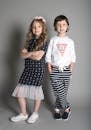 Two children posing in stylish nautical-themed outfits.
